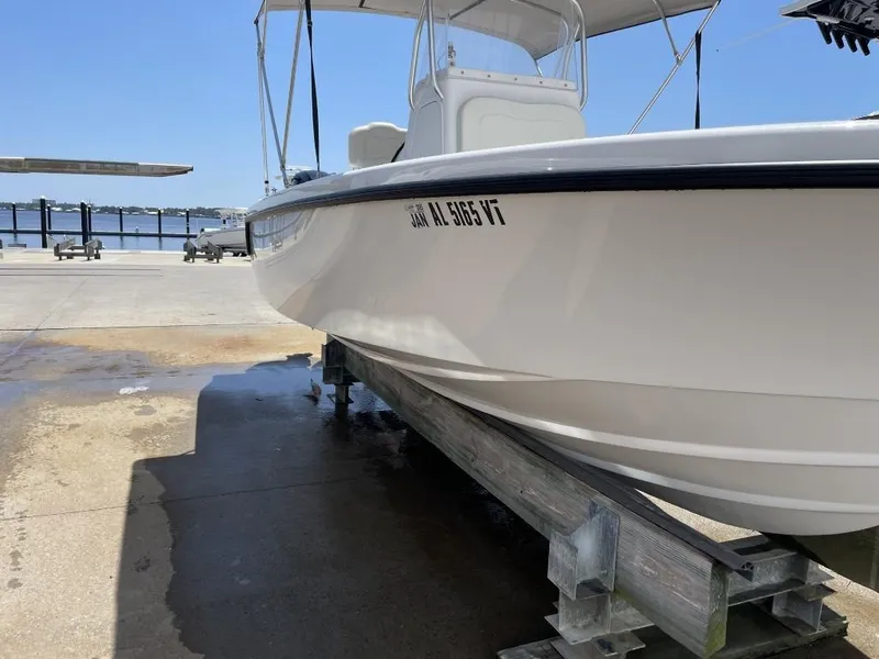 Slide: The Image of 2024 Reef Runner 230 XO boat on a dock under a clear blue sky. - 10