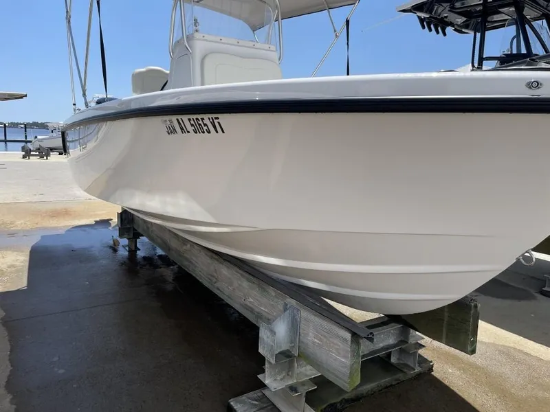Slide: The Image of 2024 Reef Runner 230 XO boat on dock under clear blue sky. - 11