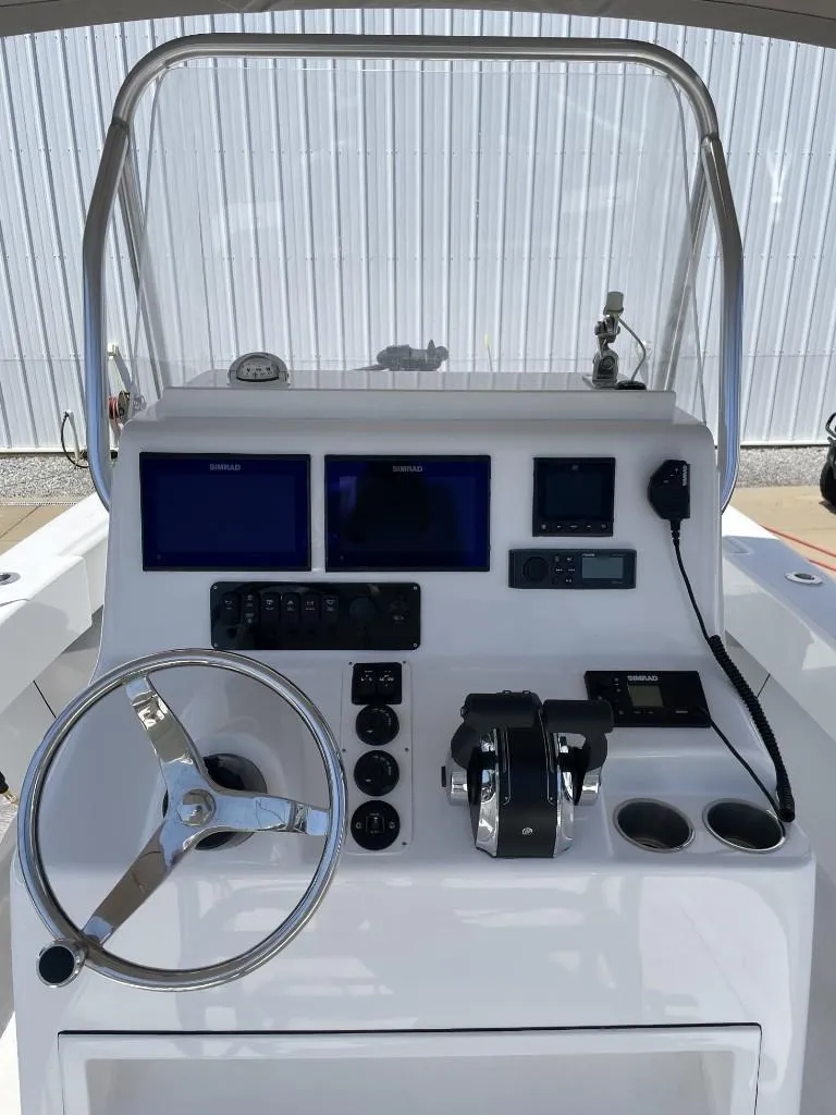 Slide: The Image of 2024 Reef Runner 230 XO boat console with steering wheel and navigation controls. - 14