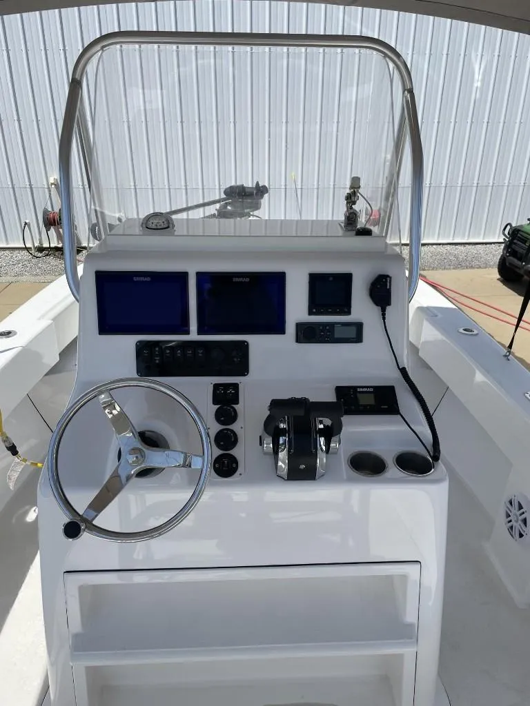 Slide: The Image of 2024 Reef Runner 230 XO boat console with steering wheel, controls, and navigation screens. - 15
