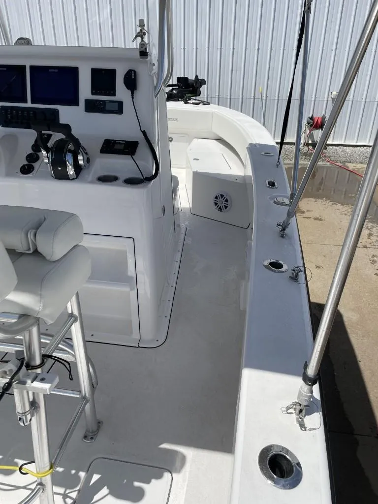 Slide: The Image of 2024 Reef Runner 230 XO boat interior with helm, seating, and fishing rod holders. - 24