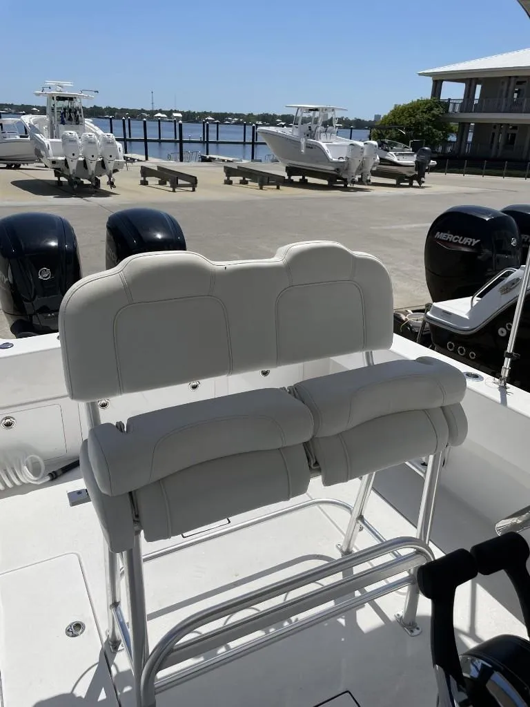 Slide: The Image of 2024 Reef Runner 230 XO boat with dual engines, docked near waterfront. - 26