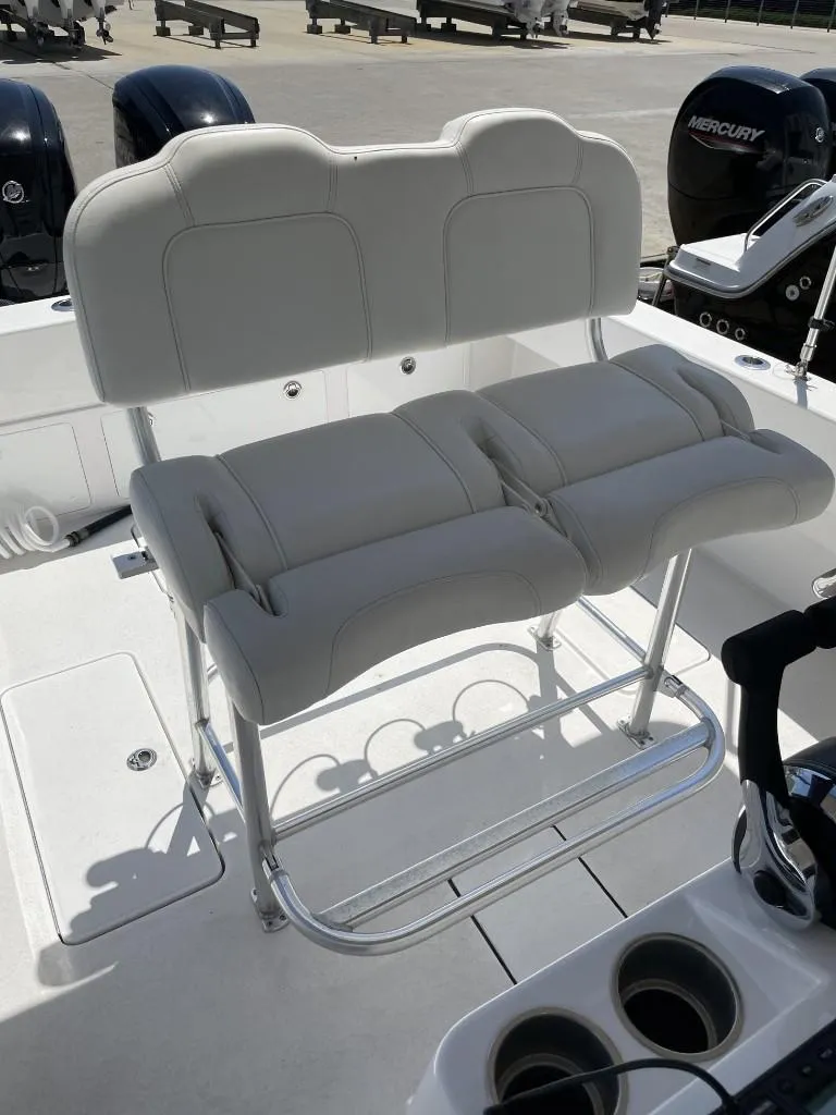 Slide: The Image of 2024 Reef Runner 230 XO boat with cushioned seating and dual Mercury engines. - 28