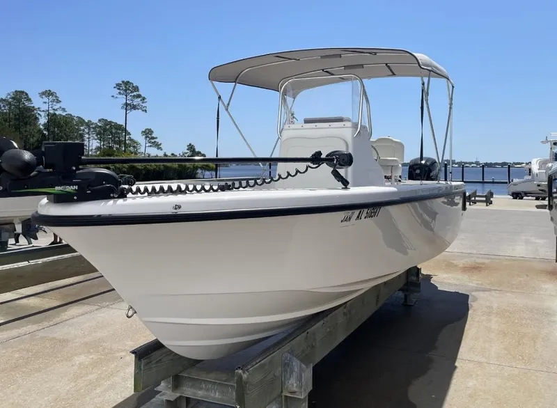 Slide: The Image of 2024 Reef Runner 230 XO boat on dock, featuring sleek design and canopy. - 3