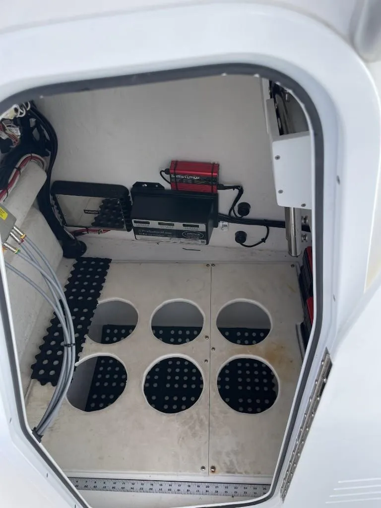 Slide: The Image of 2024 Reef Runner 230 XO boat interior with storage compartments and electronic equipment. - 31