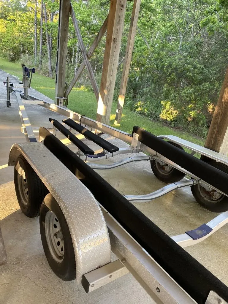Slide: The Image of Boat trailer for 2024 Reef Runner 230 XO, parked outdoors on concrete. - 38