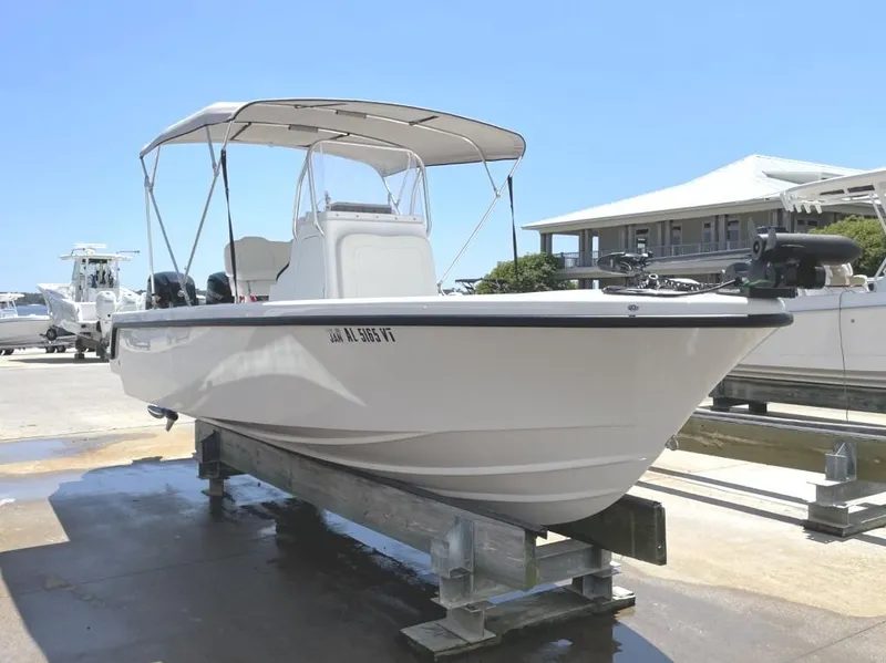 Slide: The Image of 2024 Reef Runner 230 XO boat on a dock, featuring a sleek white design and canopy. - 4