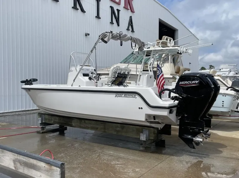 Slide: The Image of 2024 Reef Runner 230 XO boat with Mercury engine at marina. - 5