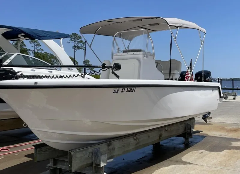 Slide: The Image of 2024 Reef Runner 230 XO boat on display, featuring a sleek white design and canopy. - 6