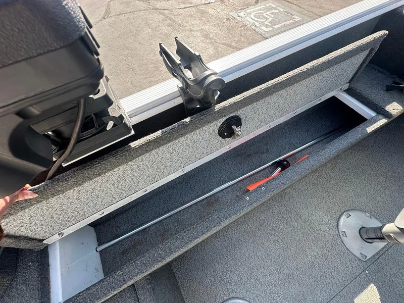 Slide: The Image of 2011 Lund 1625 Rebel XL Sport boat interior with storage compartment and rod holder. - 17