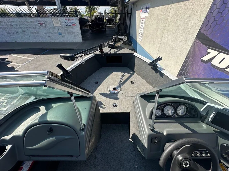 Slide: The Image of 2011 Lund 1625 Rebel XL Sport boat interior with steering console and fishing rod holders. - 29