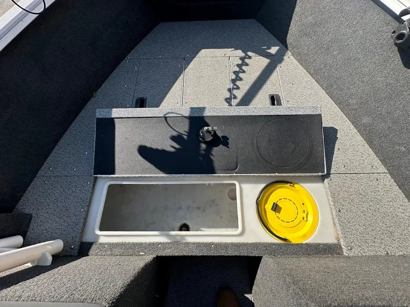 Slide: The Image of 2011 Lund 1625 Rebel XL Sport boat interior with storage compartments and carpeted flooring. - 37