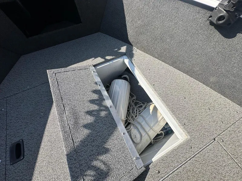 Slide: The Image of 2011 Lund 1625 Rebel XL Sport boat storage compartment with ropes and fenders. - 38