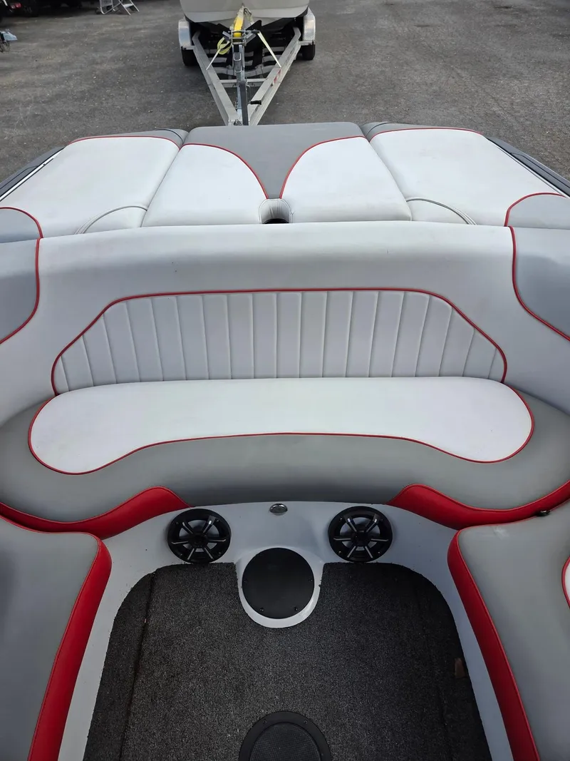 Slide: The Image of 2021 Sanger V215 S boat interior with white and red seating, speakers, and trailer. - 5
