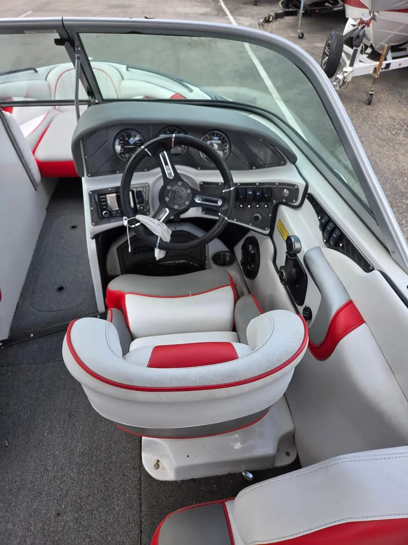 Slide: The Image of 2021 Sanger V215 S boat interior with red and white seating and modern dashboard. - 7