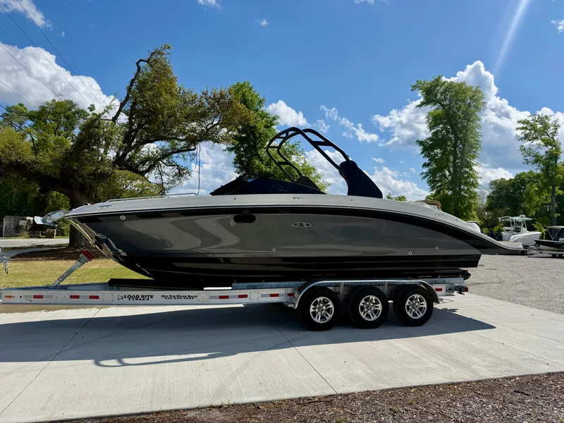 Slide: The Image of 2018 Sea Ray SDX 270 boat on a trailer, parked outdoors under a clear blue sky. - 1