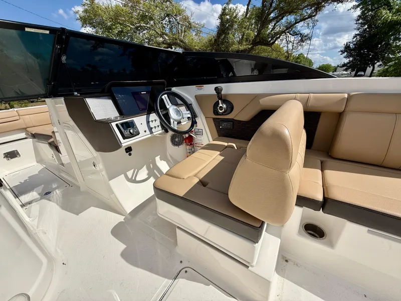 Slide: The Image of 2018 Sea Ray SDX 270 boat interior with beige seating and modern dashboard. - 10