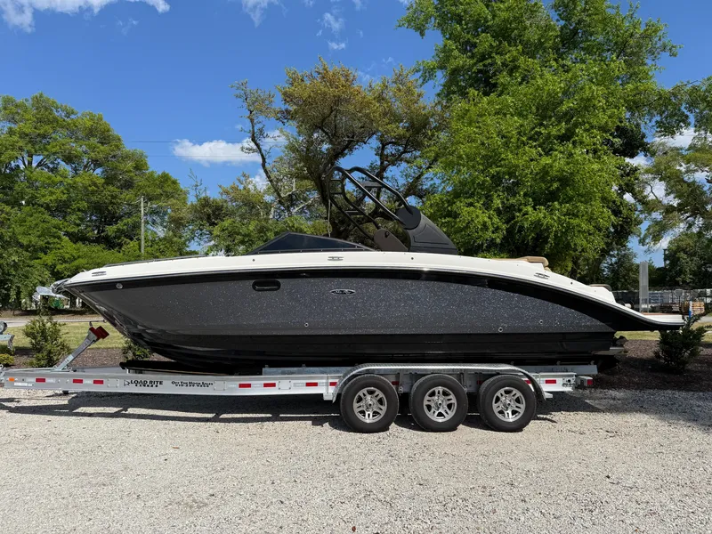 Slide: The Image of 2018 Sea Ray SDX 270 boat on a trailer, parked outdoors with trees in the background. - 19