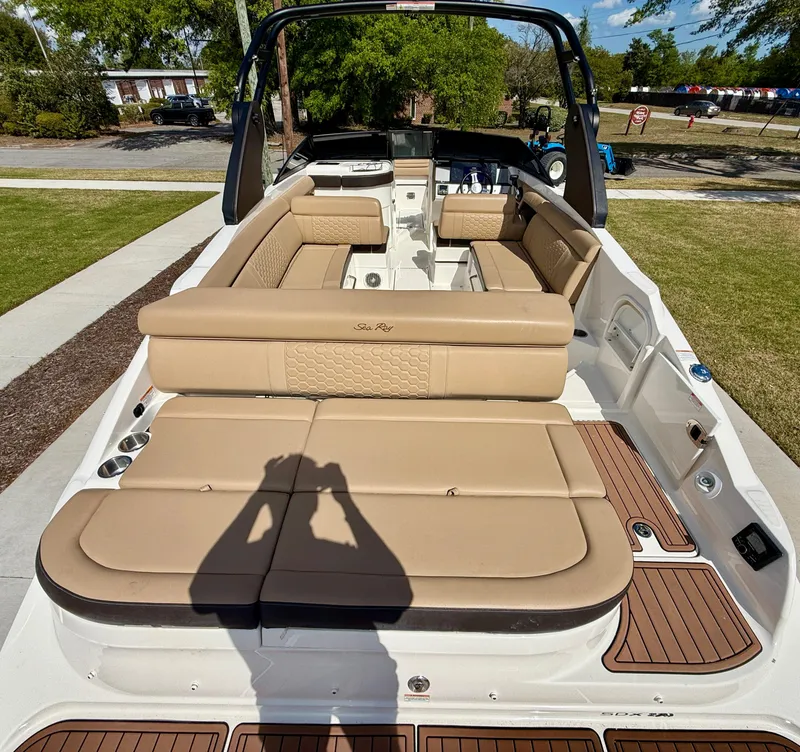 Slide: The Image of 2018 Sea Ray SDX 270 boat interior with tan seating and wood accents. - 7