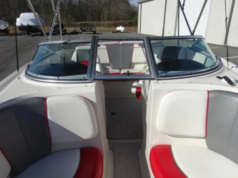 Slide: The Image of 2007 Sea Ray 185 Sport boat interior with red and white seating, docked outdoors. - 15