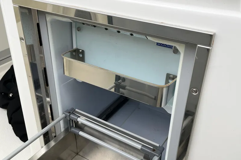 Slide: The Image of 2018 Boston Whaler 380 Outrage interior detail, featuring a stainless steel storage compartment. - 11