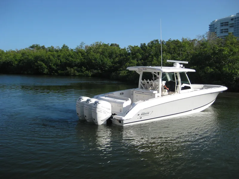 Slide: The Image of 2018 Boston Whaler 380 Outrage boat cruising on a calm river. - 2