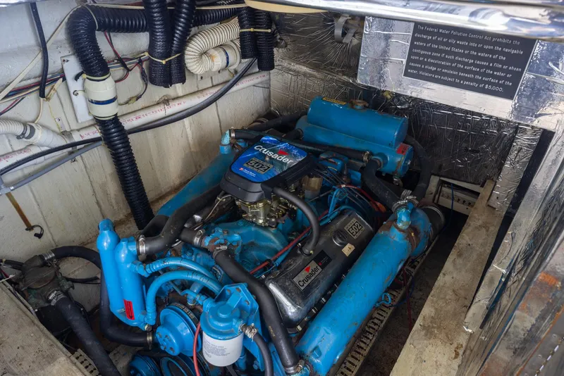 Slide: The Image of Engine room of a 1990 Bluewater Yachts 55 Yacht, featuring a blue Crusader engine. - 14