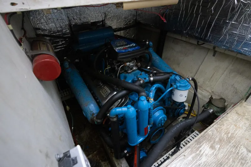 Slide: The Image of Engine compartment of a 1990 Bluewater Yachts 55 Yacht, featuring a blue marine engine. - 15