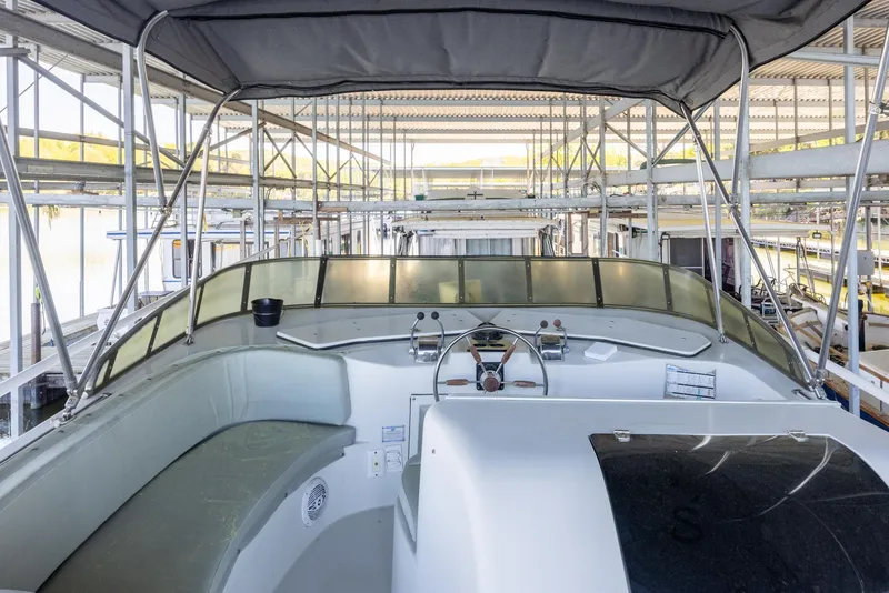 Slide: The Image of 1990 Bluewater Yachts 55 Yacht interior, featuring helm and seating under a canopy. - 4