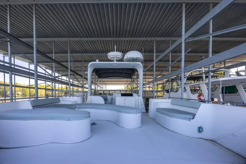 Slide: The Image of 1990 Bluewater Yachts 55 Yacht docked under a covered marina, featuring spacious deck seating. - 5