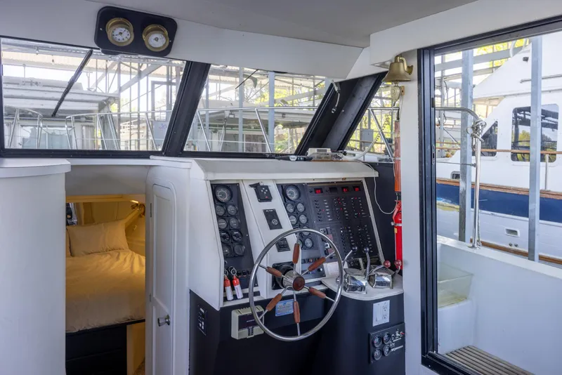 Slide: The Image of 1990 Bluewater Yachts 55 Yacht helm with steering wheel and control panel, docked in marina. - 9