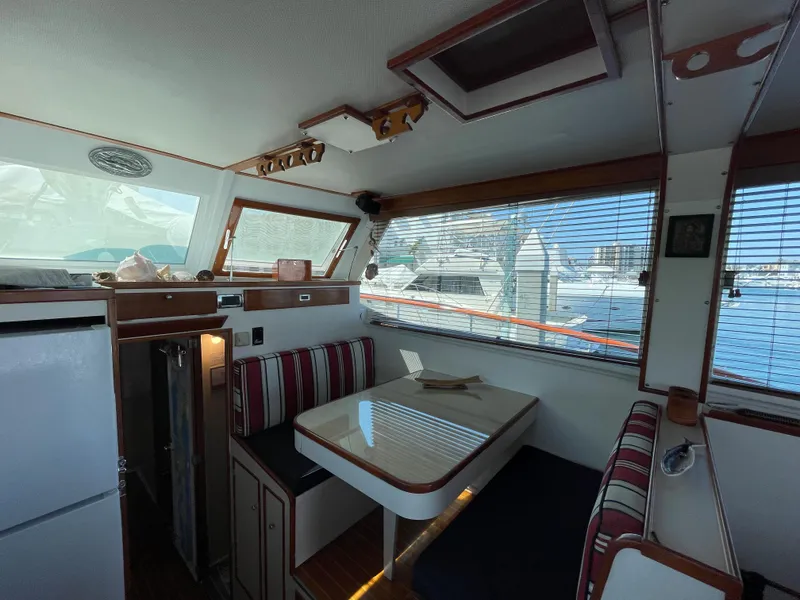 Slide: The Image of Interior of a 1966 Huckins Sportsman boat with dining area and striped seating. - 13