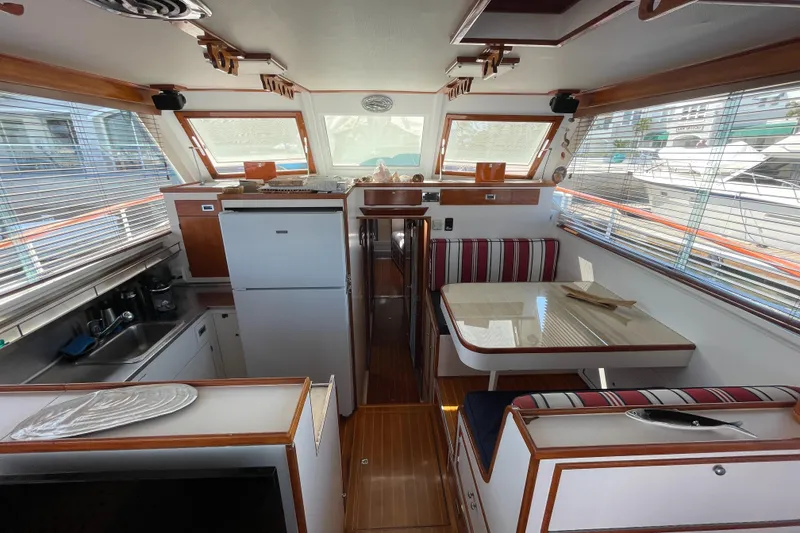 Slide: The Image of 1966 Huckins Sportsman boat interior with kitchen, dining area, and striped seating. - 15