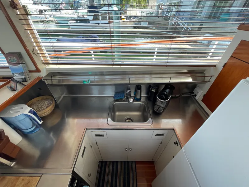 Slide: The Image of 1966 Huckins Sportsman yacht kitchen with stainless steel sink and modern appliances. - 19