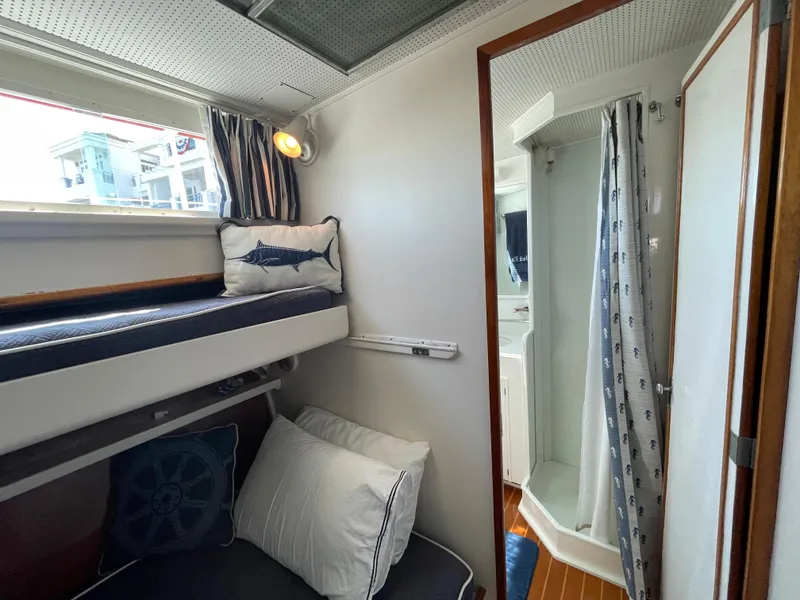 Slide: The Image of 1966 Huckins Sportsman cabin with bunk beds and compact shower area. - 25