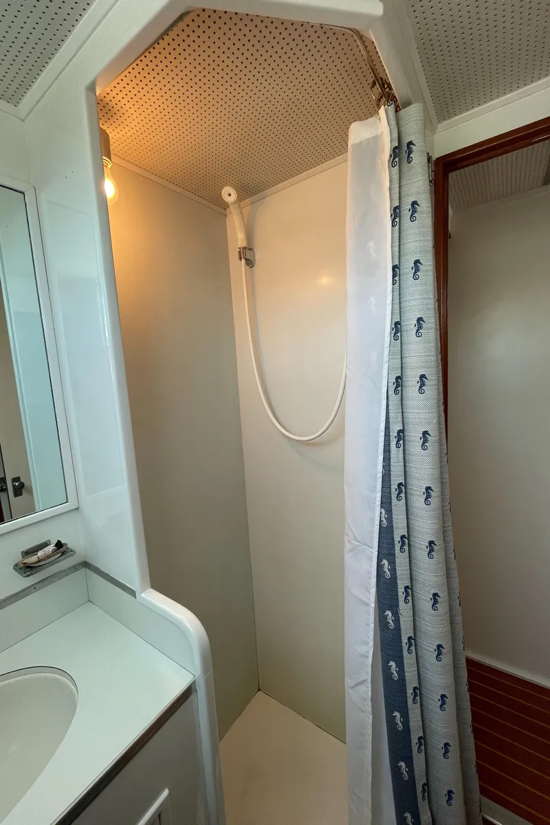 Slide: The Image of 1966 Huckins Sportsman boat shower area with curtain and sink. - 28