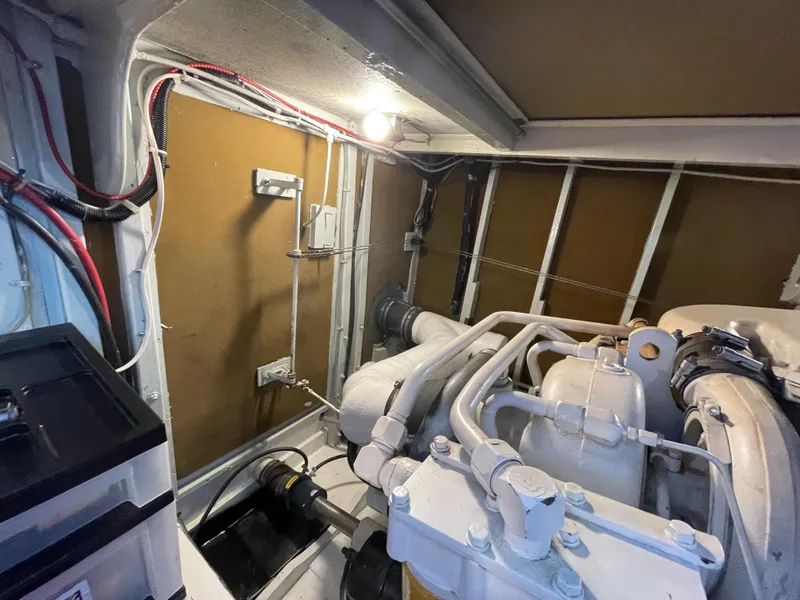 Slide: The Image of Engine room of a 1966 Huckins Sportsman boat, showcasing mechanical components and wiring. - 44