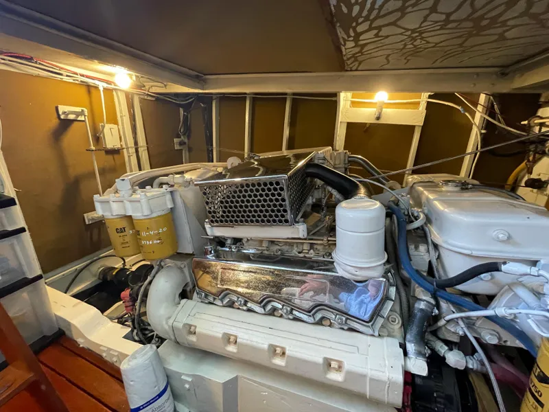 Slide: The Image of Engine room of a 1966 Huckins Sportsman boat, featuring a well-maintained engine. - 45