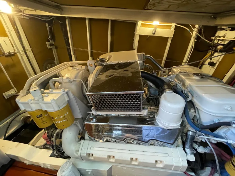Slide: The Image of Engine room of a 1966 Huckins Sportsman boat, showcasing detailed mechanical components. - 46