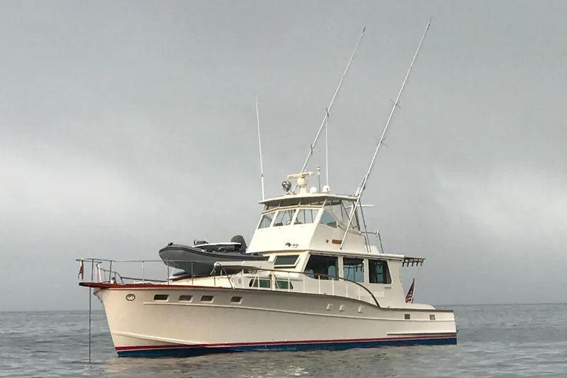 Slide: The Image of 1966 Huckins Sportsman boat on calm water under overcast sky. - 5