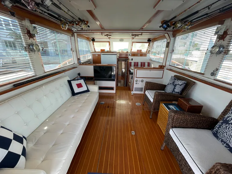 Slide: The Image of 1966 Huckins Sportsman interior with elegant seating, wooden flooring, and nautical decor. - 9