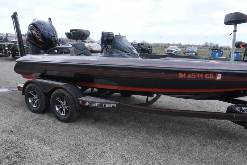 Slide: The Image of 2018 Skeeter ZX200 boat on trailer, black and red design, parked outdoors. - 13