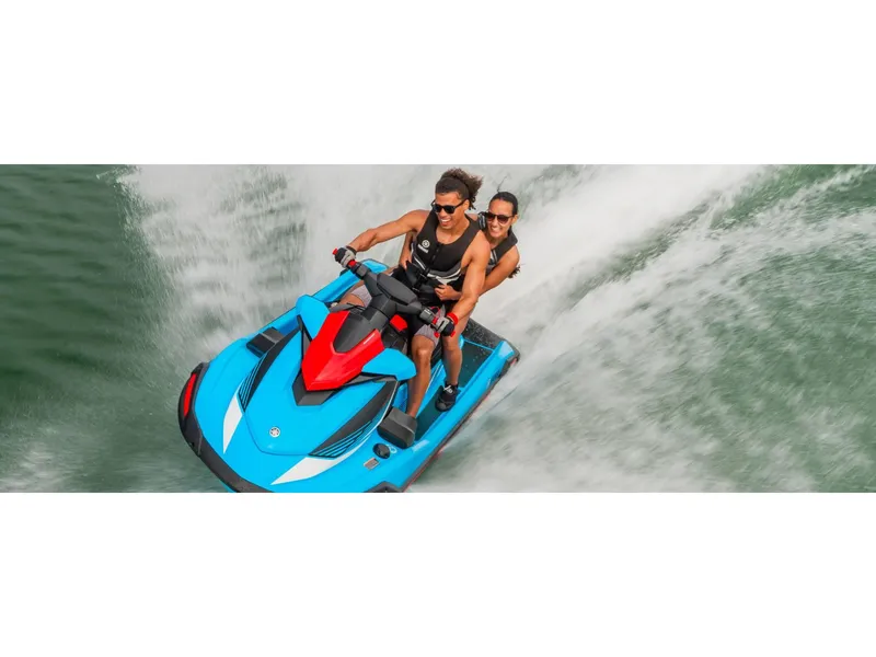 Slide: The Image of 2024 Yamaha Boats VX Deluxe jet ski with two riders speeding on water. - 7