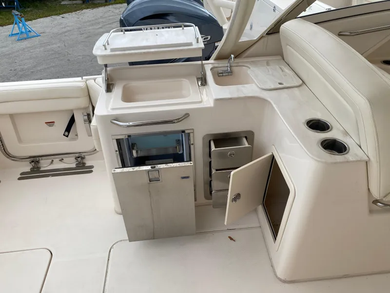 Slide: The Image of 2022 Grady-White Freedom 325 boat interior with sink, storage, and seating area. - 10