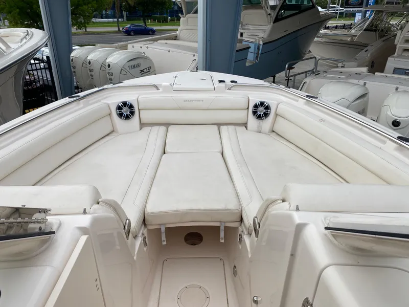 Slide: The Image of 2022 Grady-White Freedom 325 boat interior with white cushioned seating and speakers. - 4