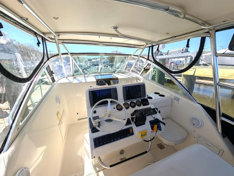 Slide: The Image of 2001 Pursuit 3070 Offshore Center Console boat interior with steering wheel and navigation equipment. - 14