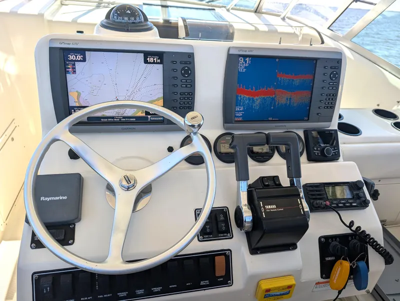 Slide: The Image of 2001 Pursuit 3070 Offshore Center Console helm with navigation screens and controls. - 15