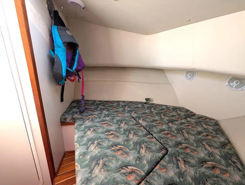 Slide: The Image of 2001 Pursuit 3070 Offshore Center Console cabin with patterned cushions and life jackets. - 22