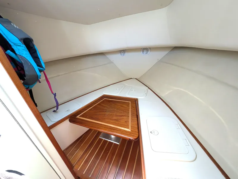 Slide: The Image of 2001 Pursuit 3070 Offshore Center Console cabin with wooden table and storage compartments. - 23