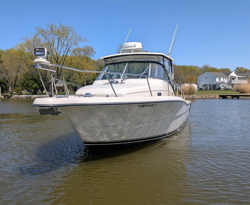 Slide: The Image of 2001 Pursuit 3070 Offshore Center Console boat on calm water, clear sky background. - 9